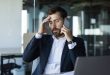 concerned-male-entrepreneur-talking-cellphone-touching-head-stress-having-unpleasant-mobile-call