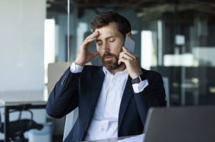 concerned-male-entrepreneur-talking-cellphone-touching-head-stress-having-unpleasant-mobile-call